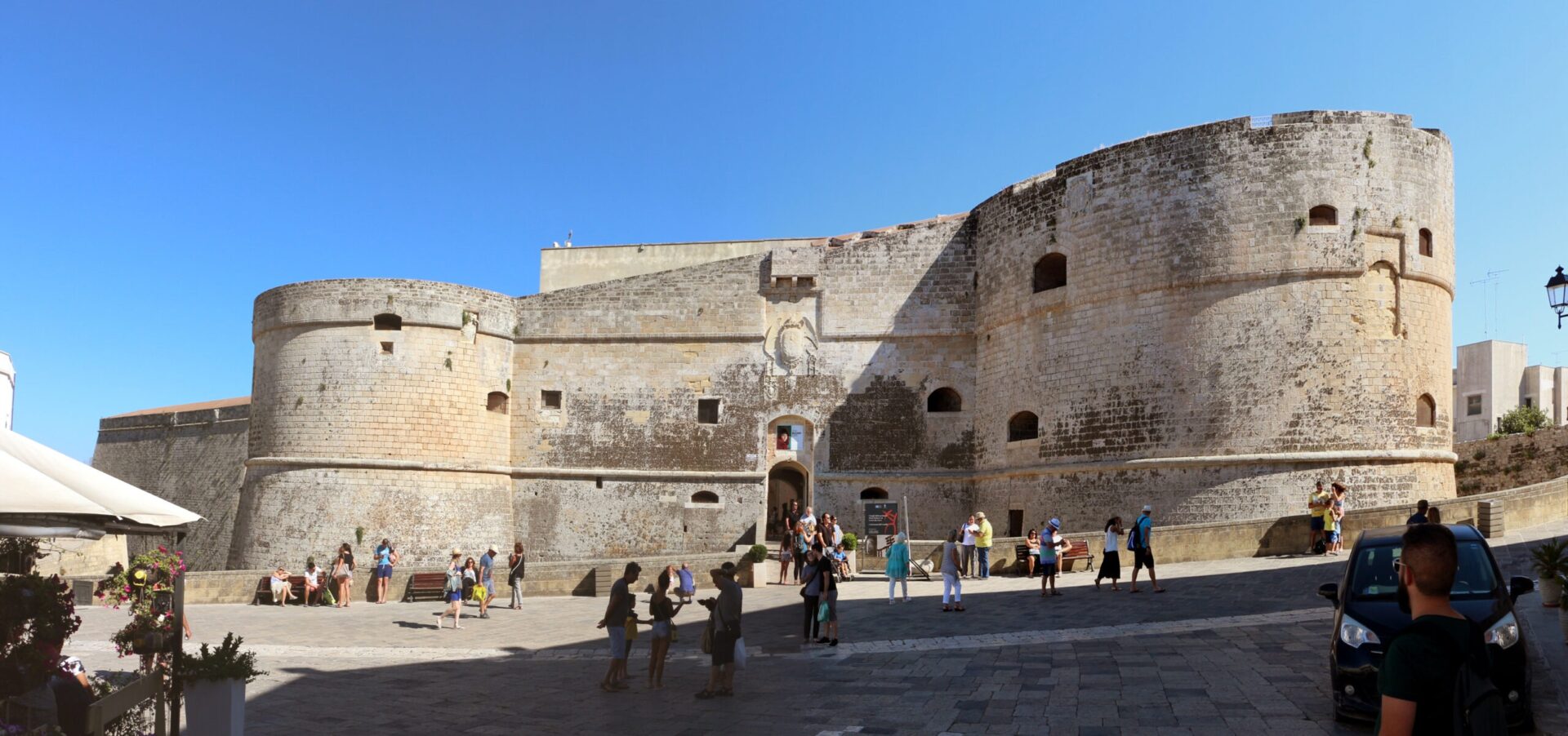 Aragonese Castle entrance in Otranto with cylindrical towers and stone bridge, now a cultural hub