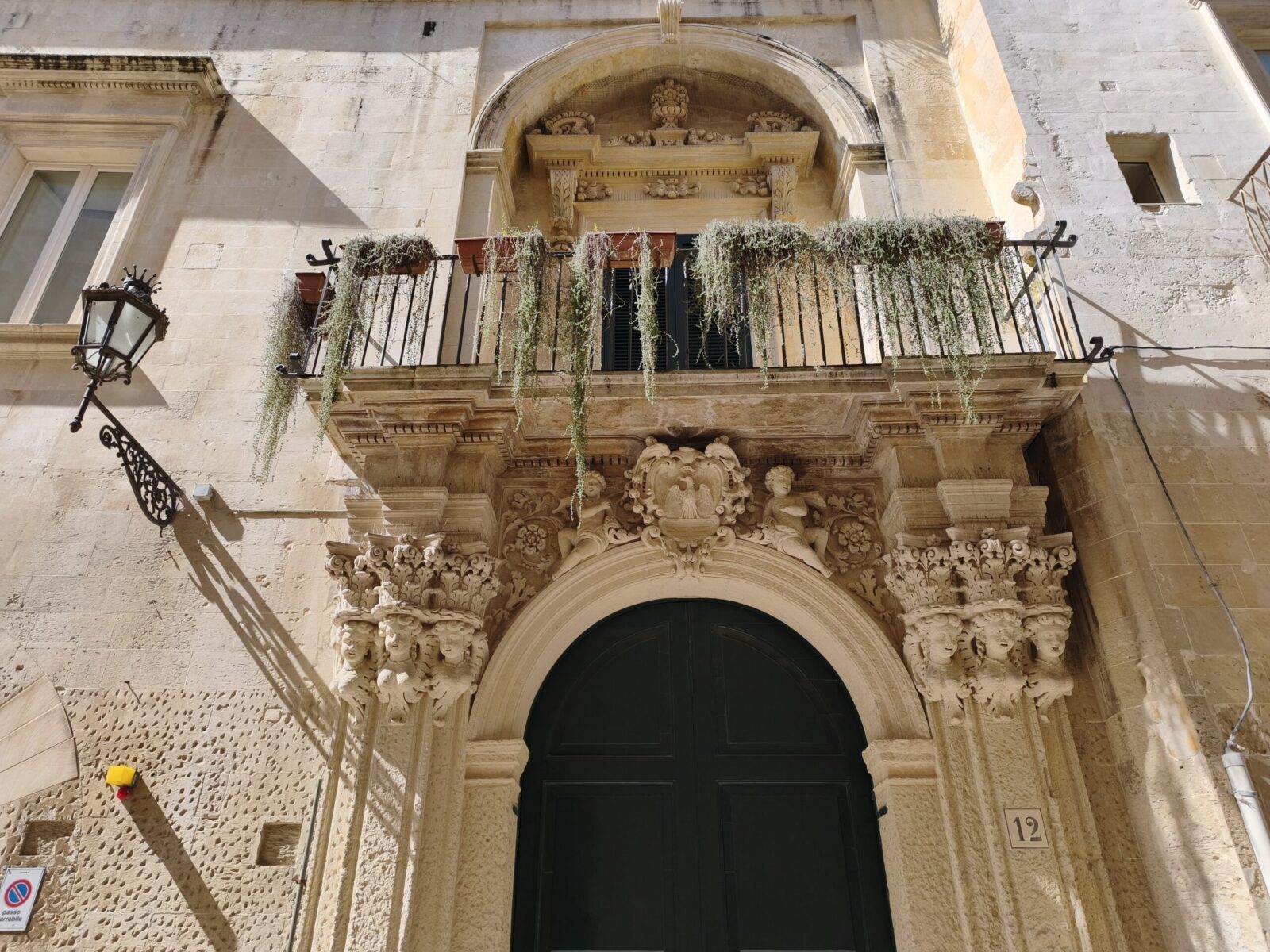 Close-up detail of floral Baroque carvings on a stone portal in Lecce showing acanthus leaves and putti