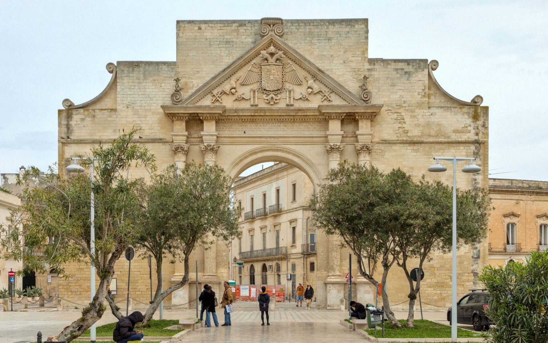Porta Napoli triumphal arch in Lecce with three arcades and Corinthian columns celebrating Charles V