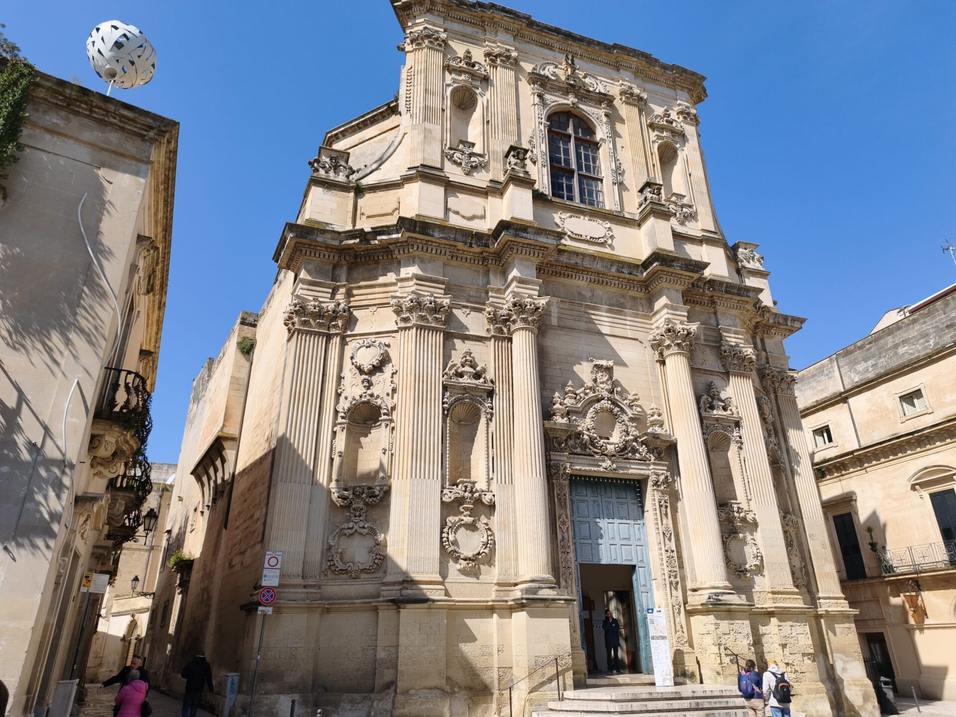 Santa Irene Church facade in Lecce with ornate Baroque carvings and a large central window